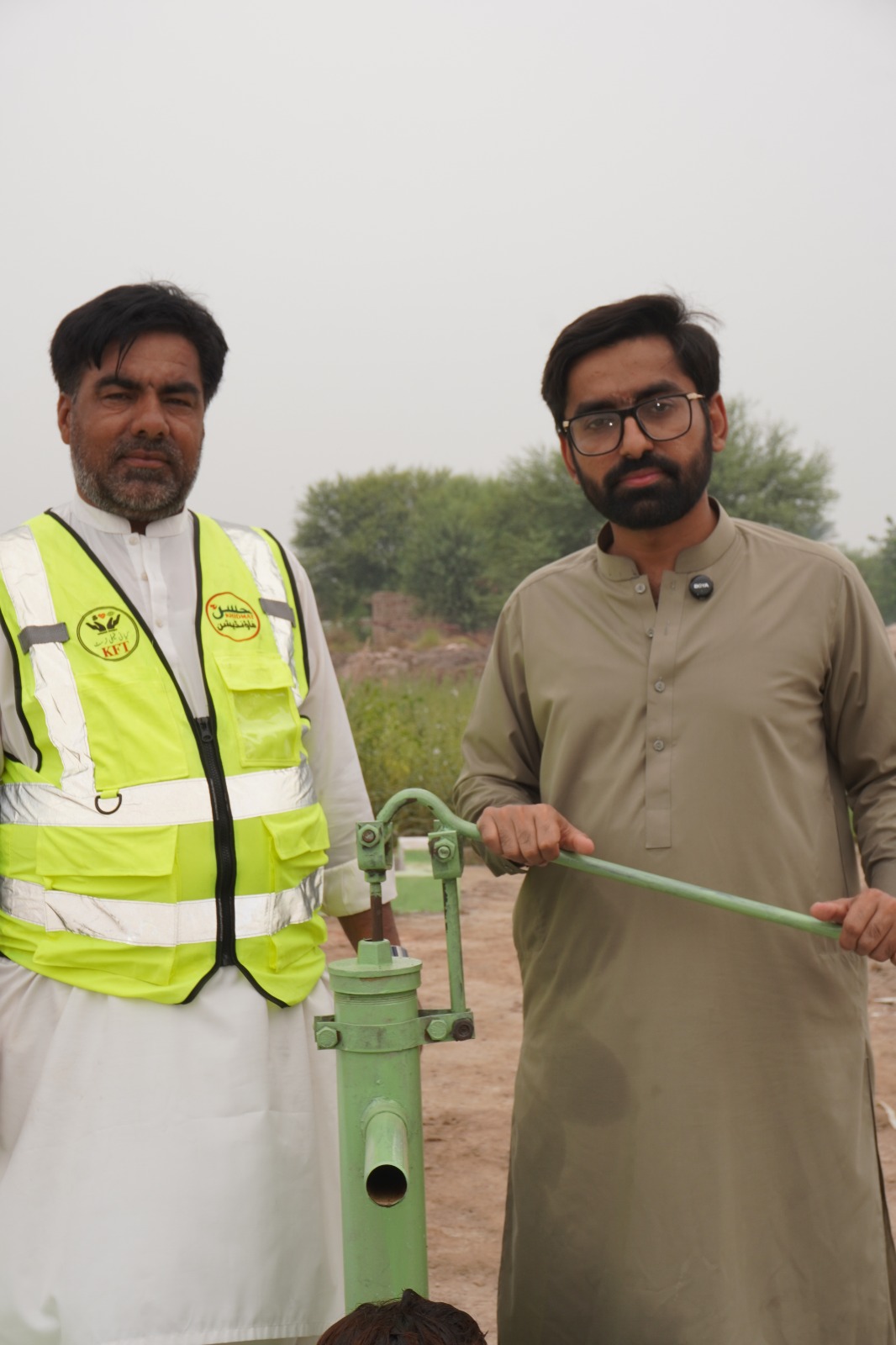 Foundation representatives at a newly installed hand pump